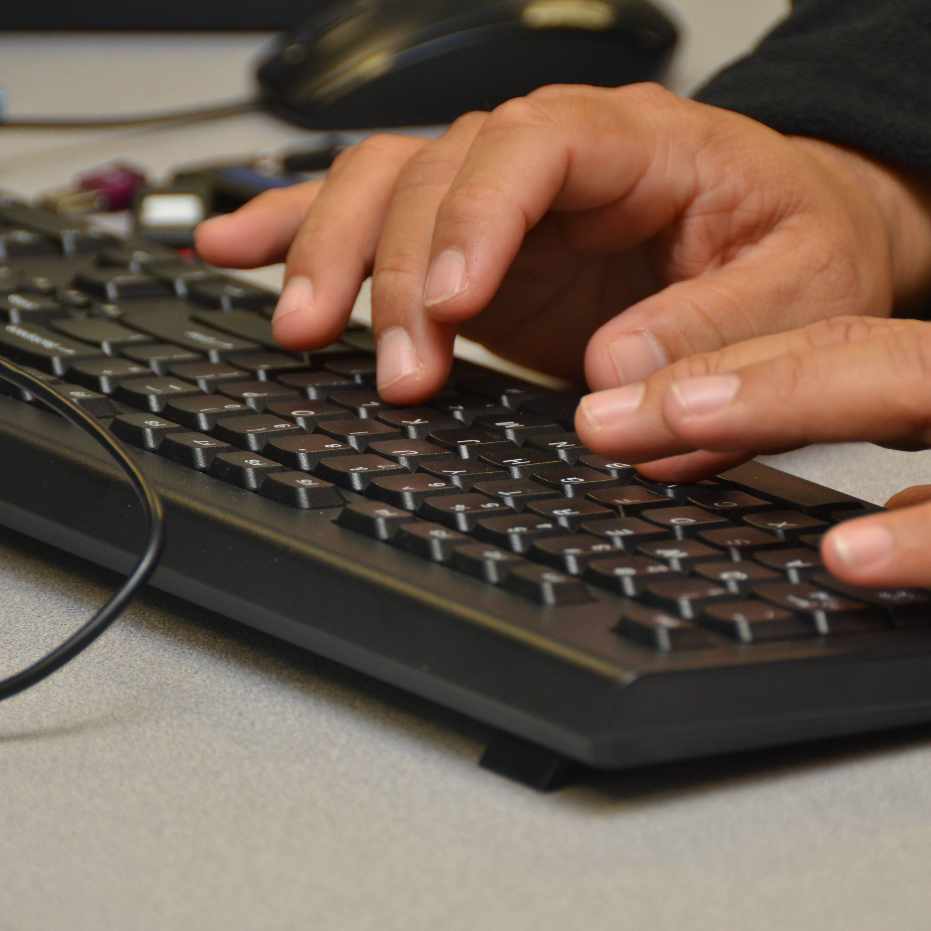 student typing on a keyboard